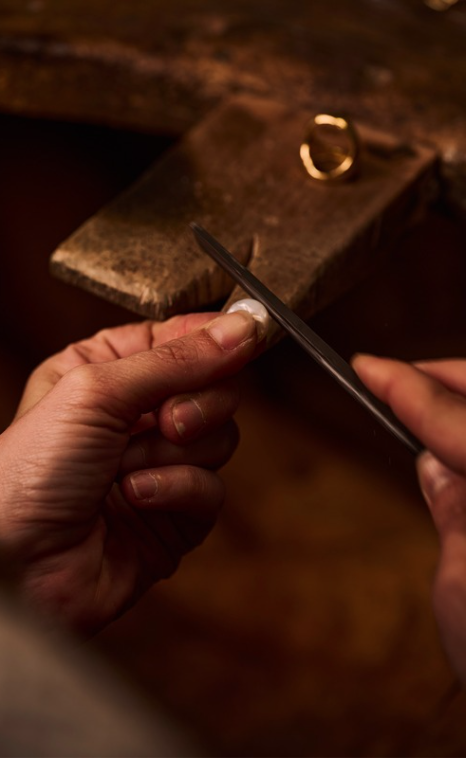Deux mains qui travaillent à la cheville d'un établi sur un bijou